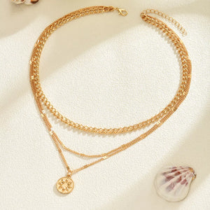 Gold layered pendant necklace with coin charm and lace trim detail