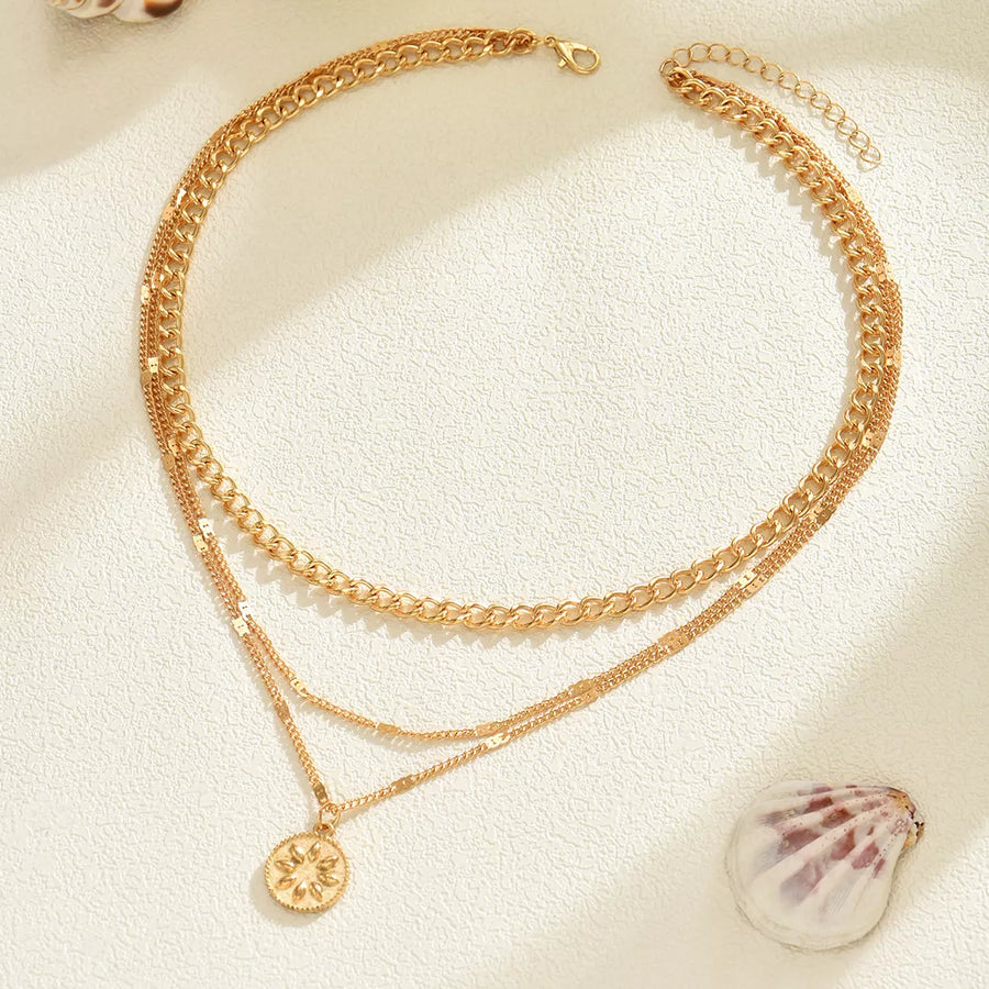 Gold layered pendant necklace with coin charm and lace trim detail