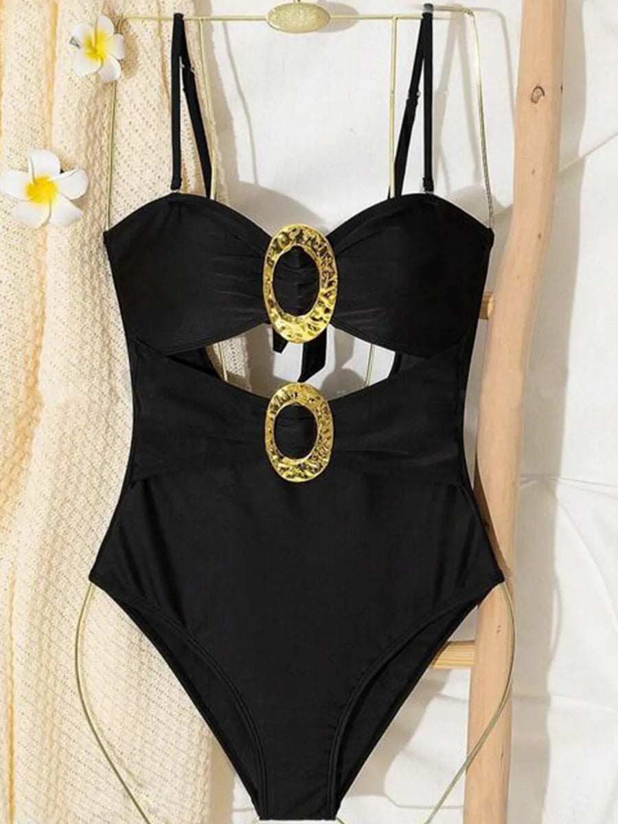 Black one-piece swimsuit with cutout detail and gold oval ring accents.