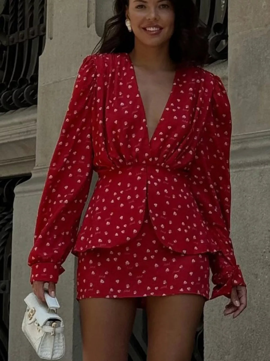 Red printed mini dress with plunging neckline, long sleeves, and cinched waist.