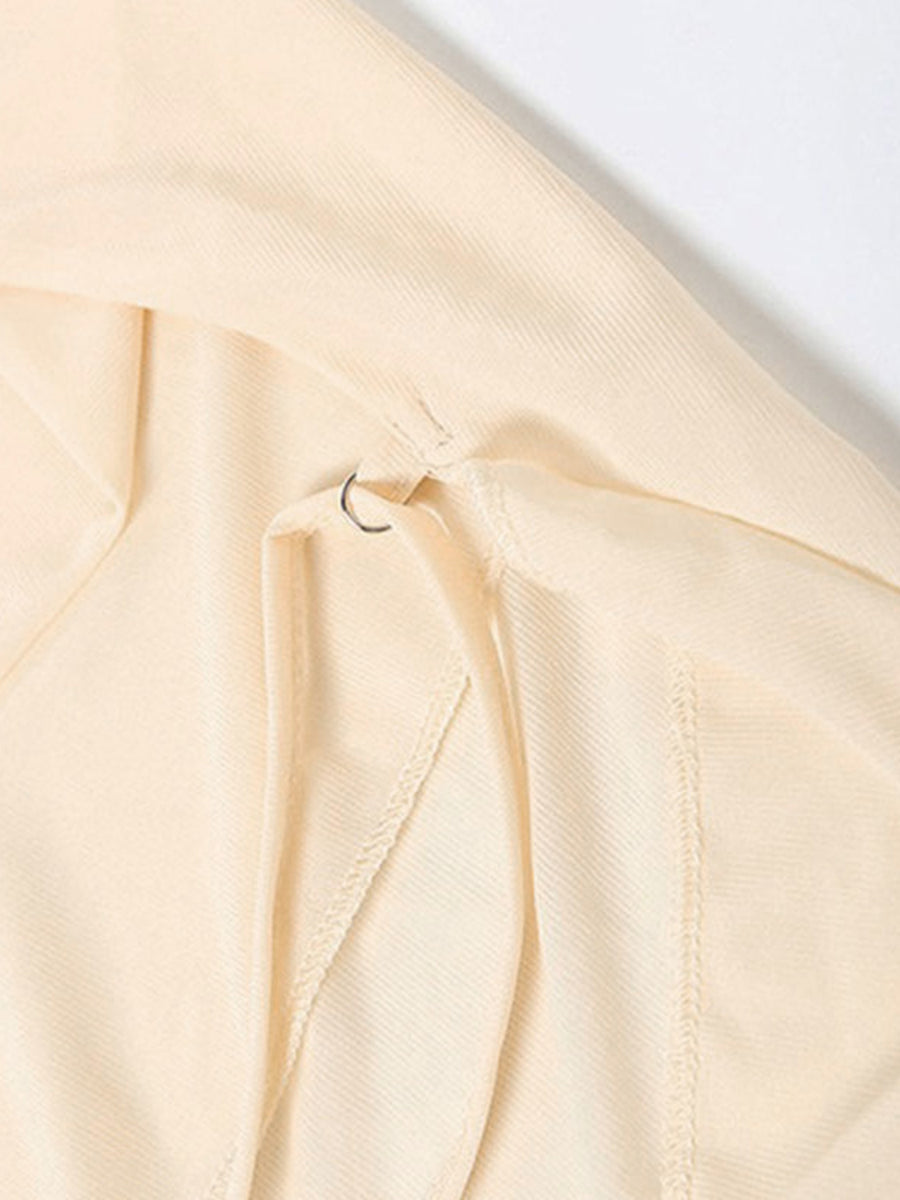 Backless ruffled mini dress in cream with a metal ring detail at the back closure.