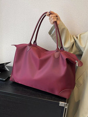 Burgundy Oxford cloth travel tote with leather trim and double handles.