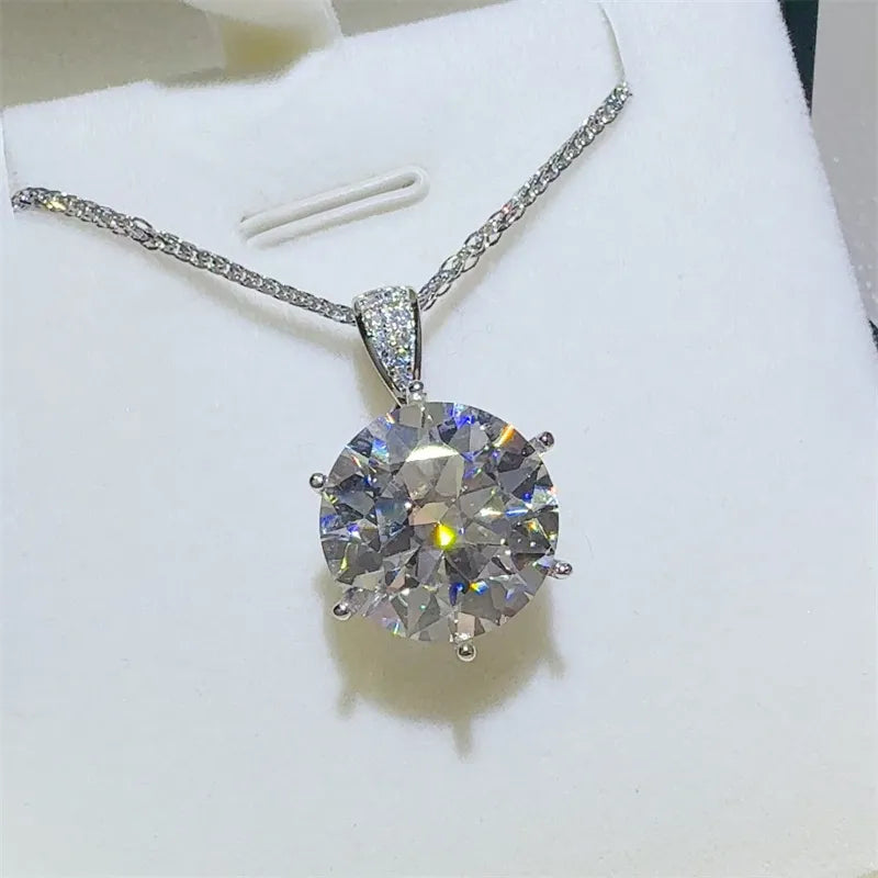 Silver moissanite solitaire pendant with a sparkling round-cut stone and diamond-accented bail.