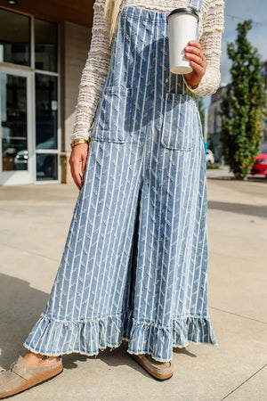 Striped distressed denim overalls with wide legs and ruffled hems.