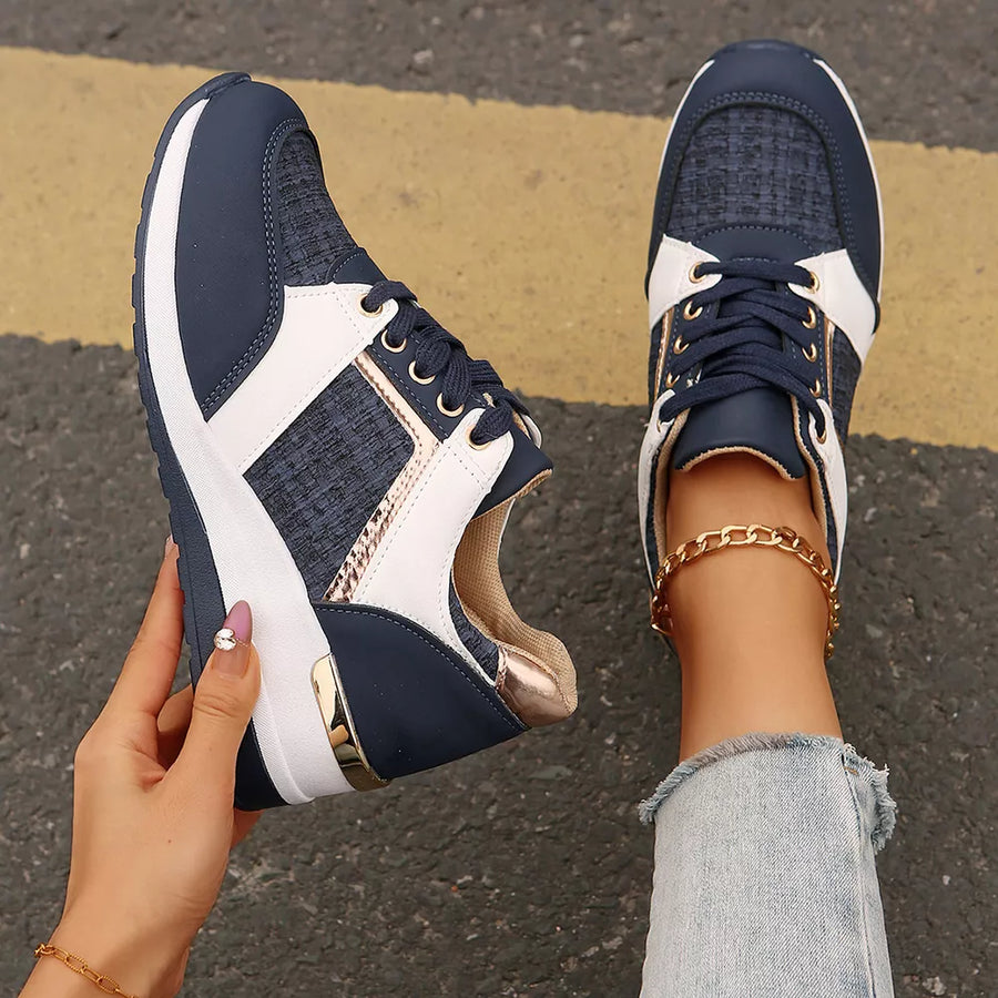 Dark blue lace-up sneakers with white and metallic accents and a chunky sole.
