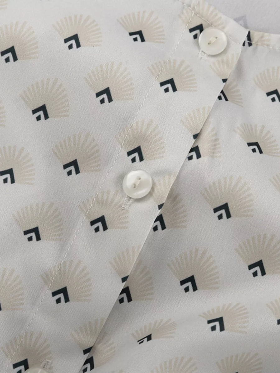 White blouse with fan and square pattern, featuring button closure.