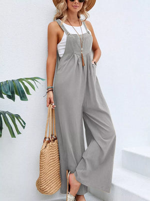 Light gray wide-leg romper with adjustable straps and pockets, worn with a white tank top.