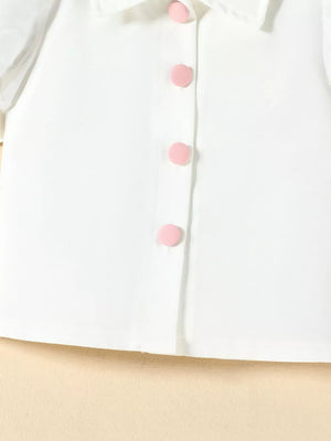 White baby top with puff sleeves and pink button details
