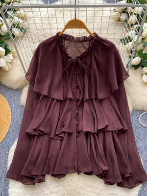 Brown chiffon blouse with tiered ruffles, bow tie neck and button front.