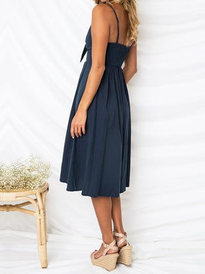 Dark blue midi sundress with smocked bodice, bow front, and button detail.