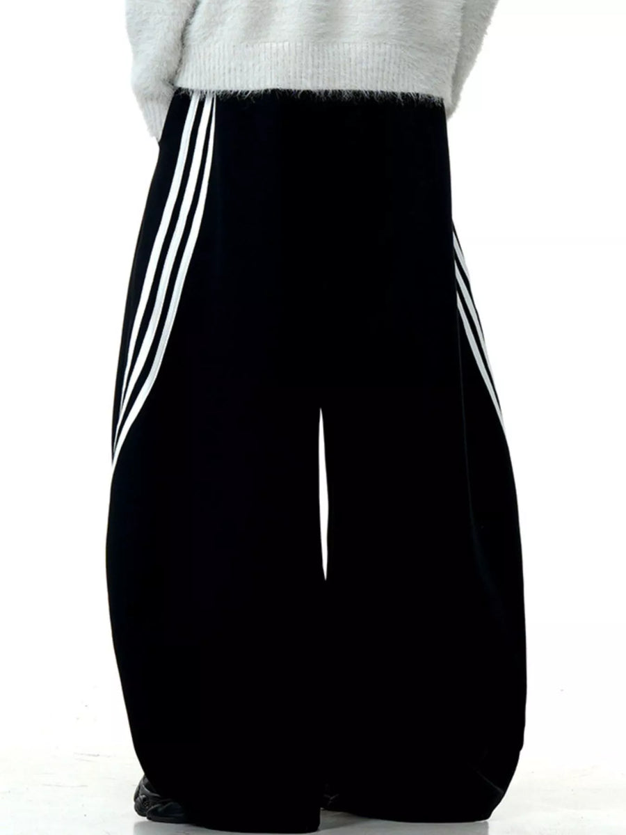 Men's black wide-leg sweatpants with white side stripes and a relaxed fit.