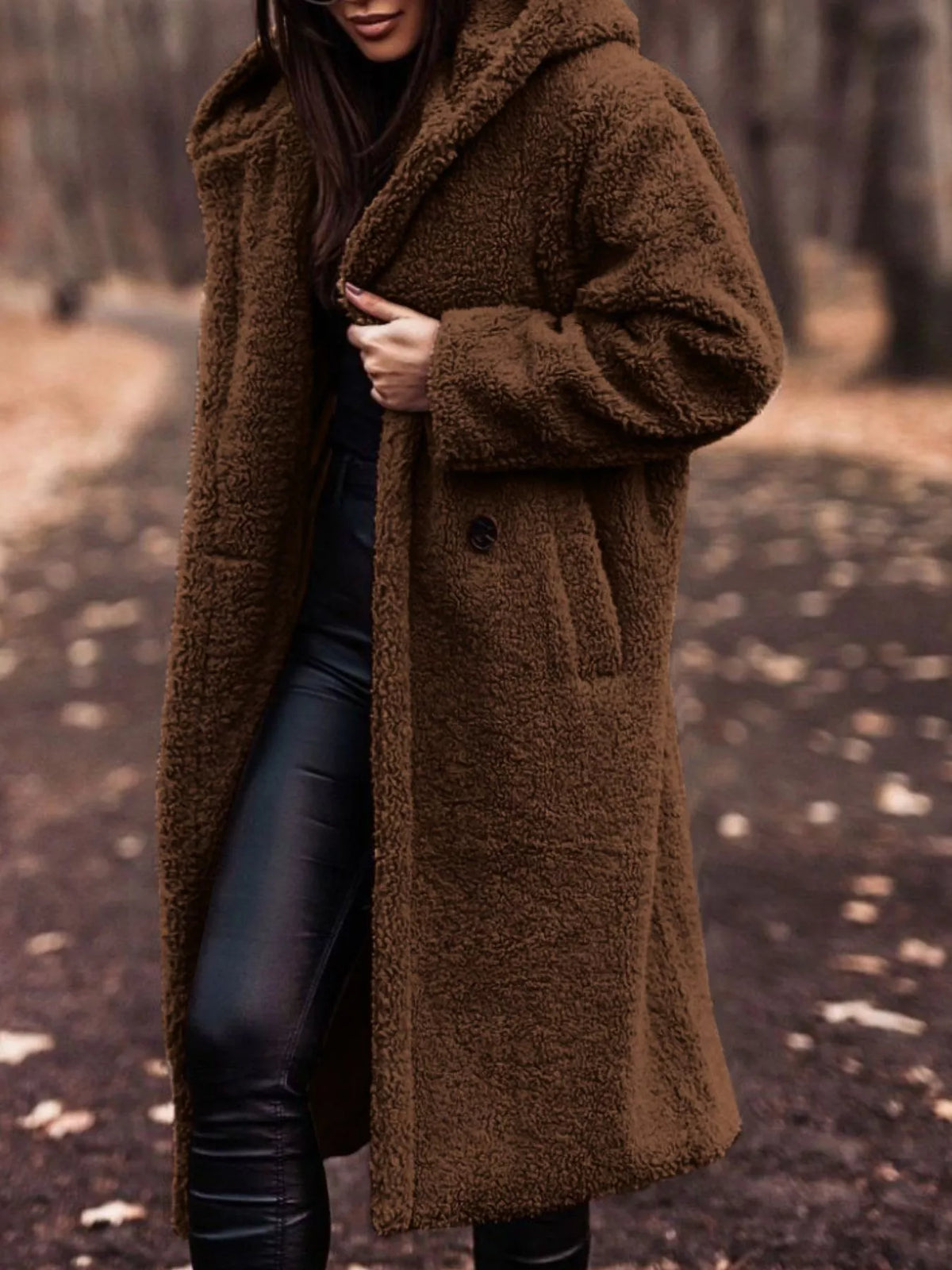 Brown teddy bear longline coat with hood and button closure, styled with black leather pants.