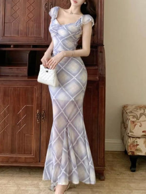 Ruched plaid bodycon maxi dress in blue with sweetheart neckline and ruffled cap sleeves.