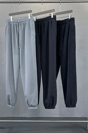 Relaxed fit sweatpants in gray and black with drawstring waist and cuffed ankles.