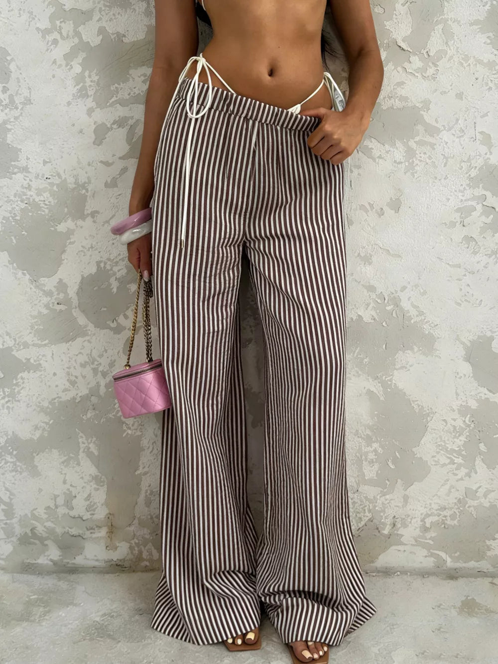 Tied striped wide-leg pants in brown and white, featuring a high waist and flowy silhouette.