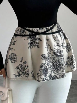 Peplum top with black floral print and black trim detail at waist