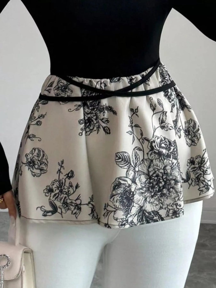 Peplum top with black floral print and black trim detail at waist