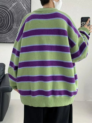 Oversized green striped V-neck cardigan with purple and light blue stripes.