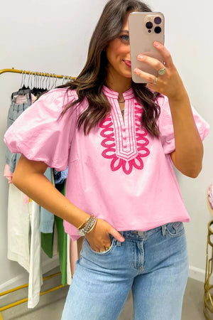 Pink cotton shirt with puff sleeves and embroidered neckline detail.