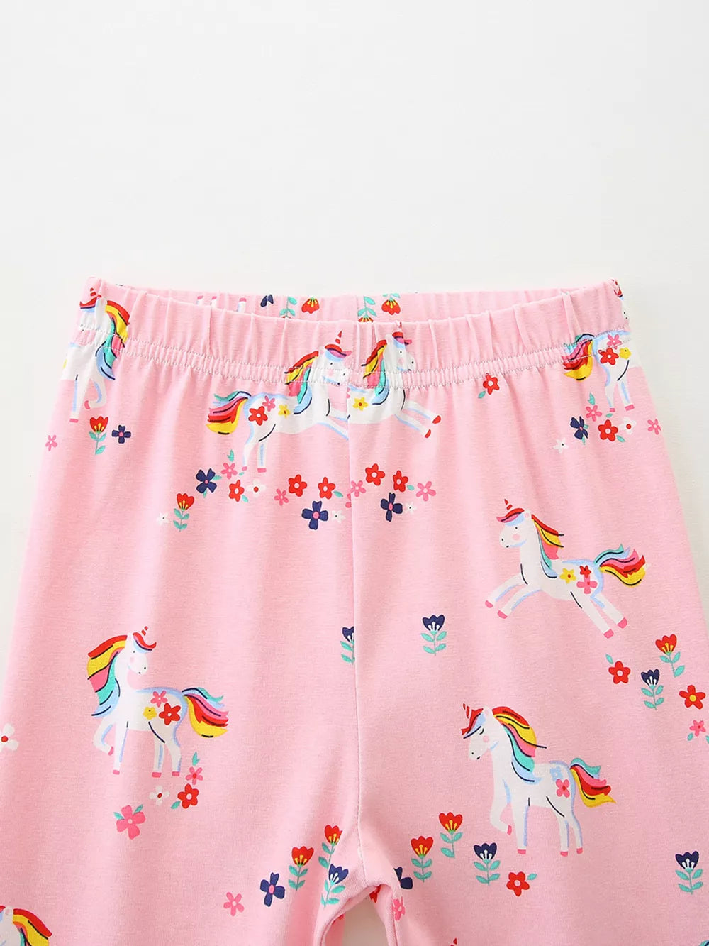Toddler pink cotton leggings with a unicorn and floral print.
