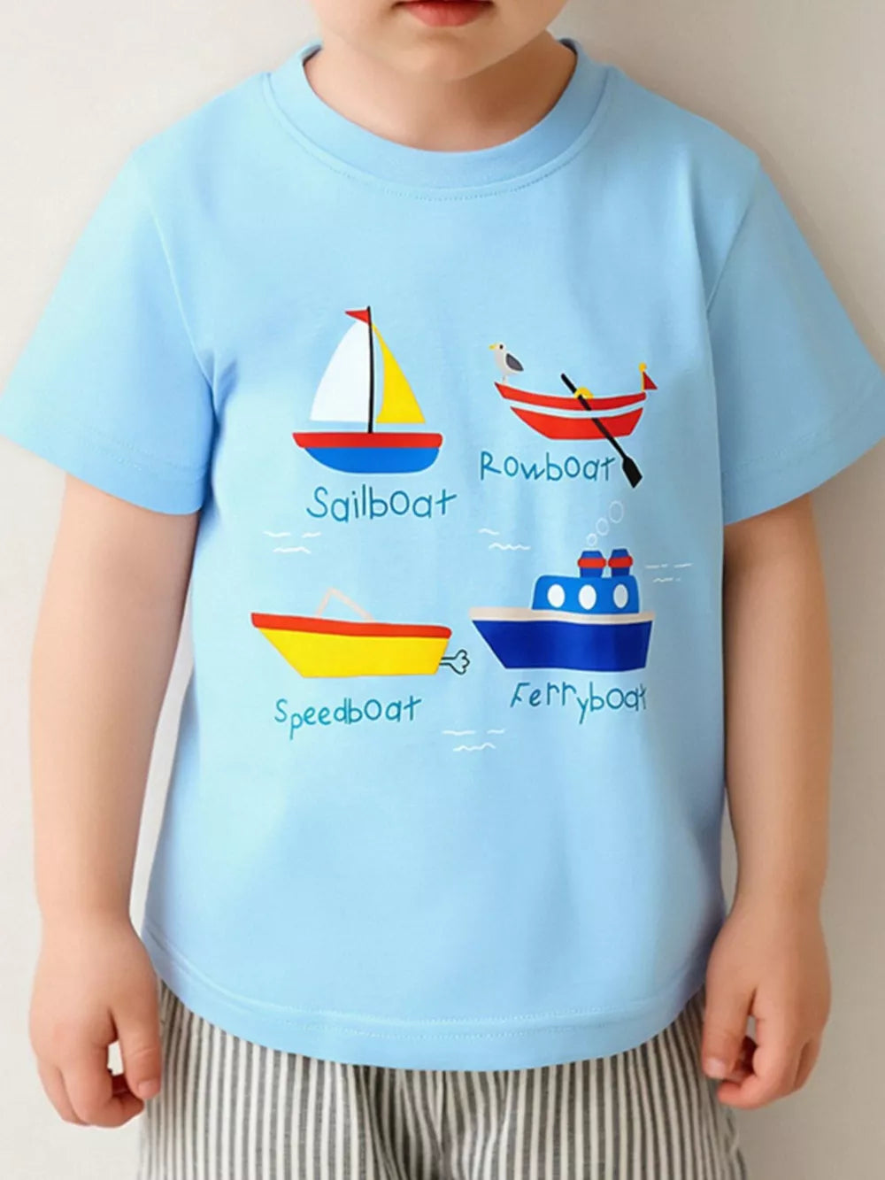 Light blue cotton t-shirt with cartoon sailboat, rowboat, speedboat, and ferryboat prints for toddlers.