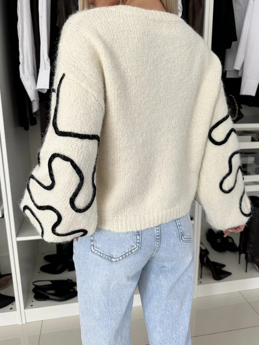black pullover sweater featuring stretch and abstract