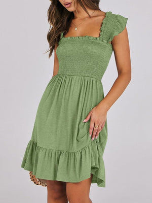 Smocked ruffle hem mini dress in sage green with square neckline and flutter sleeves.