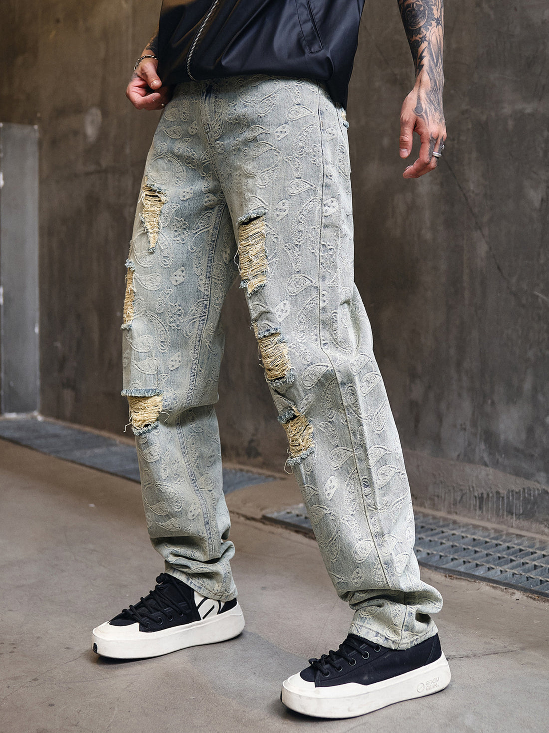 Distressed wide-leg men's jeans with paisley pattern and ripped details