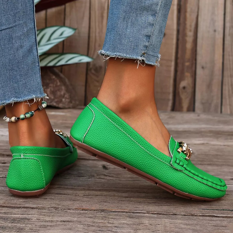 Green round-toe loafers with chain detail and contrast stitching