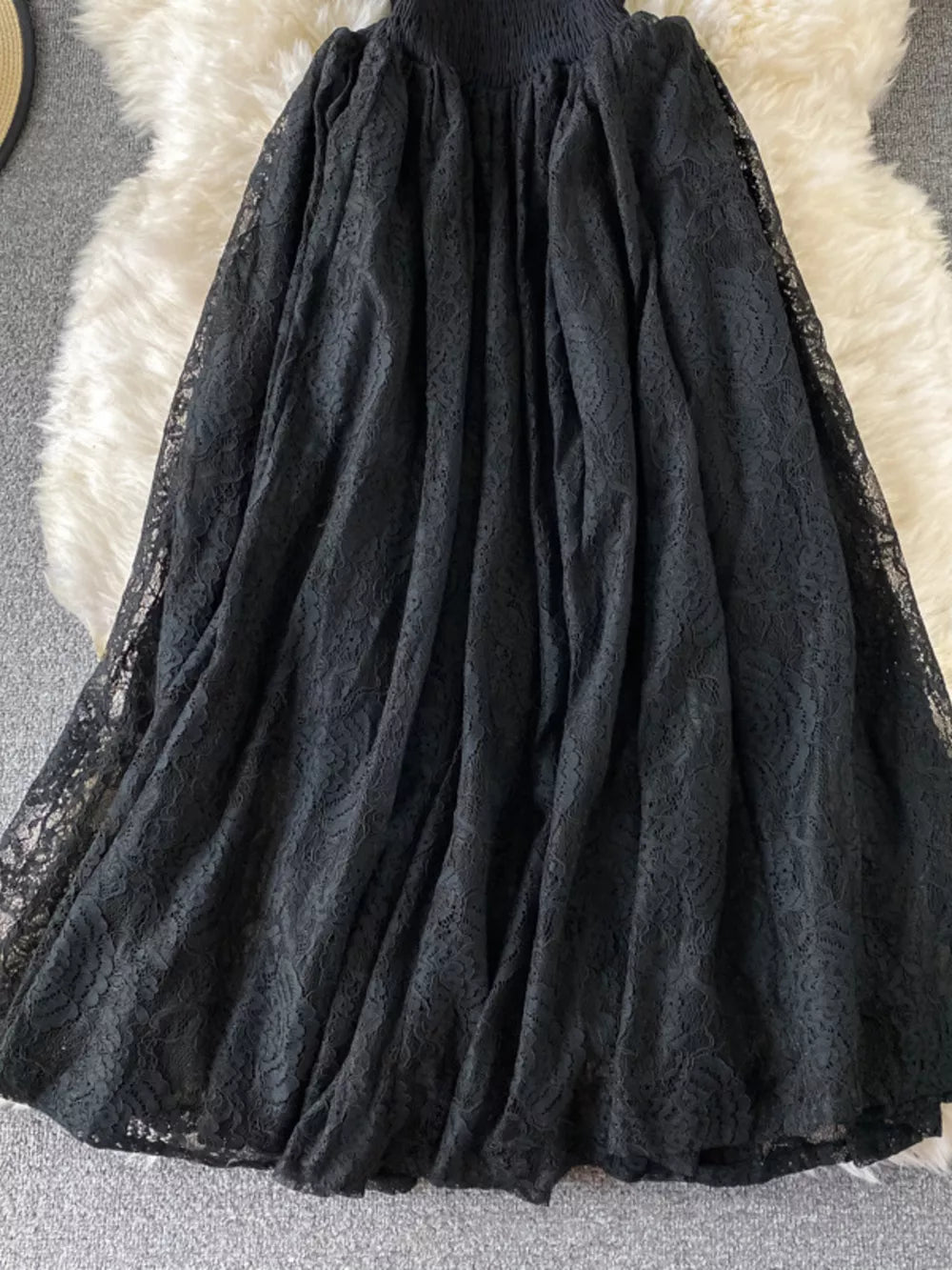 Black lace maxi dress with ruffled details and smocked bodice.