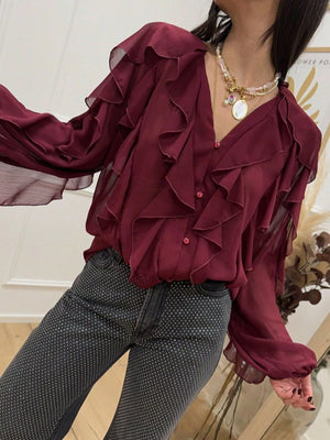 Burgundy sheer long-sleeve blouse with cascading ruffles and button front.