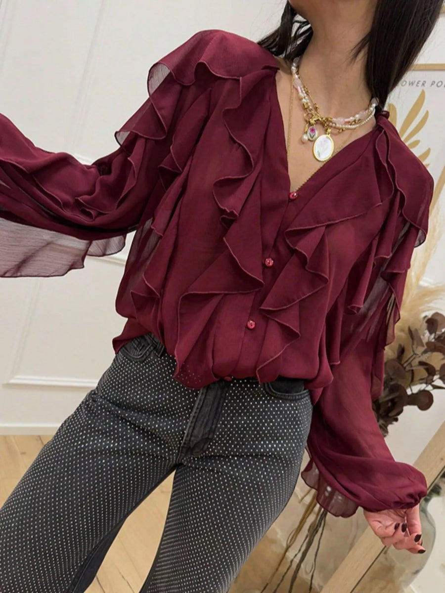Burgundy sheer long-sleeve blouse with cascading ruffles and button front.