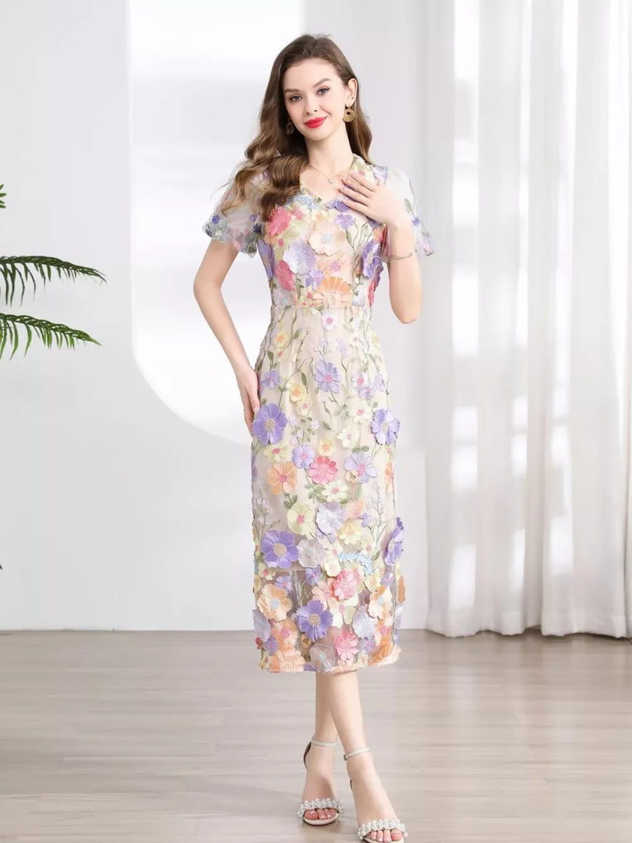 Sheath dress with colorful floral embroidery, V-neck, short puff sleeves, and midi length.