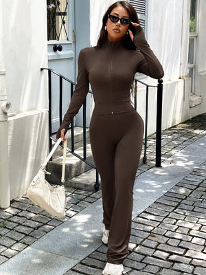 Brown zippered activewear set with mock neck and thumbhole sleeves.