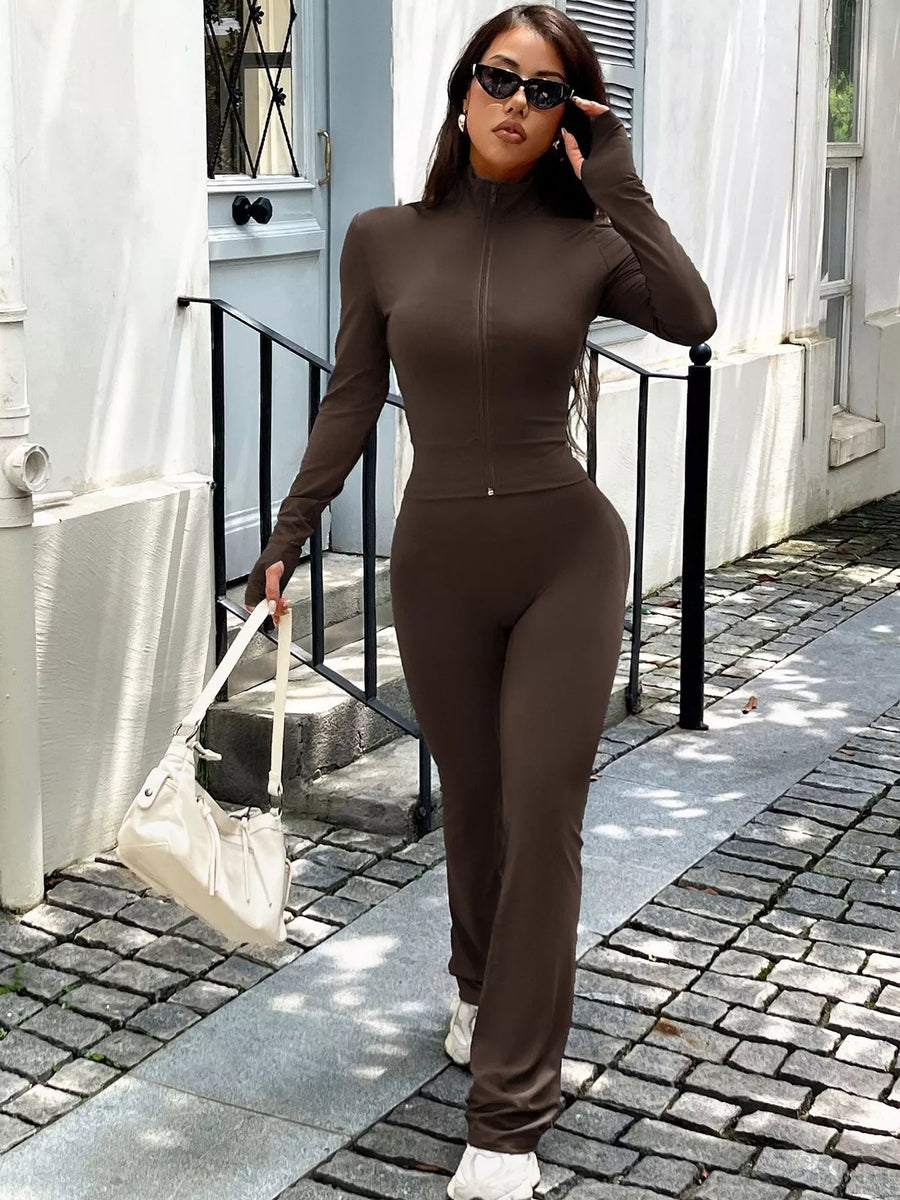 Brown zippered activewear set with mock neck and thumbhole sleeves.