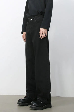 Black denim balloon trousers with a relaxed fit and visible stitching detail.