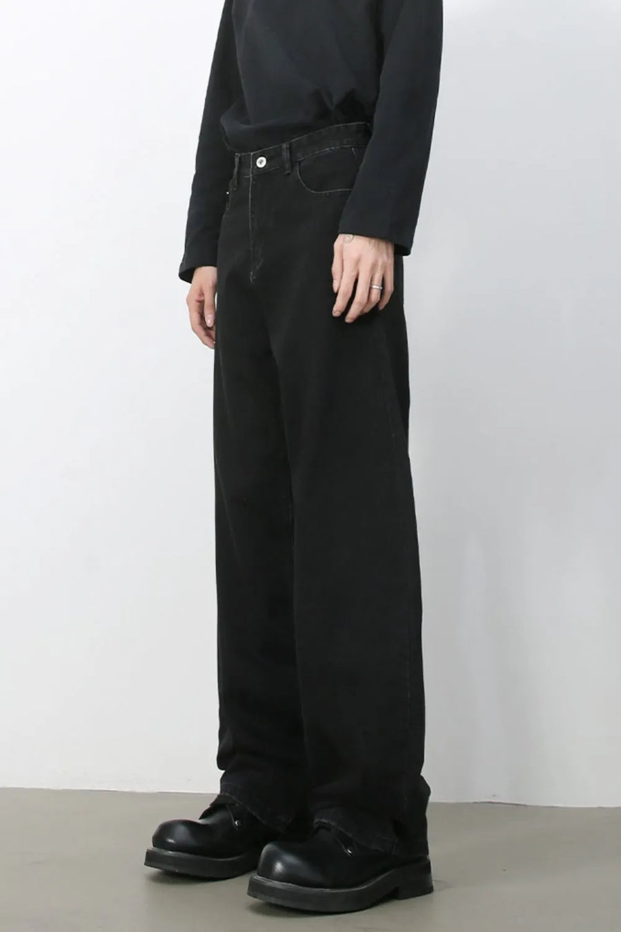 Black denim balloon trousers with a relaxed fit and visible stitching detail.