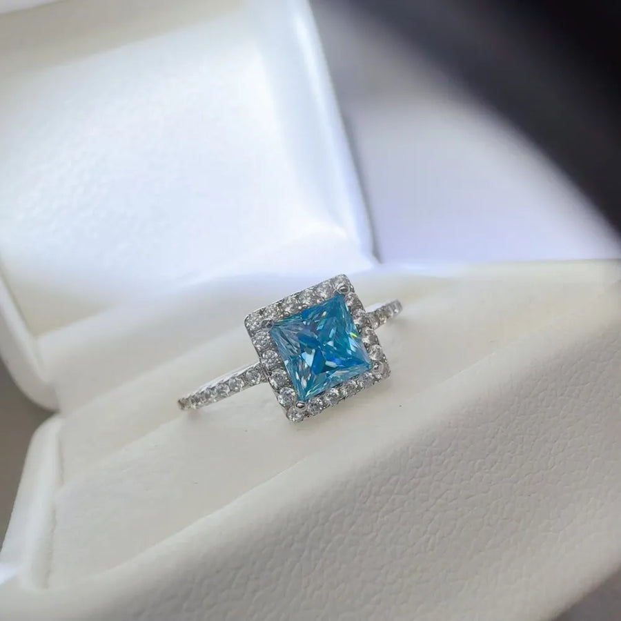 Silver ring with ice blue square halo diamond accent.