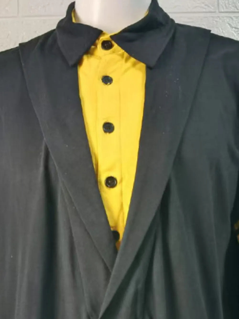Black polo shirt with yellow front and asymmetric lapel detail.
