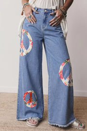 Light wash denim wide-leg jeans with floral peace sign appliqués and frayed hem.