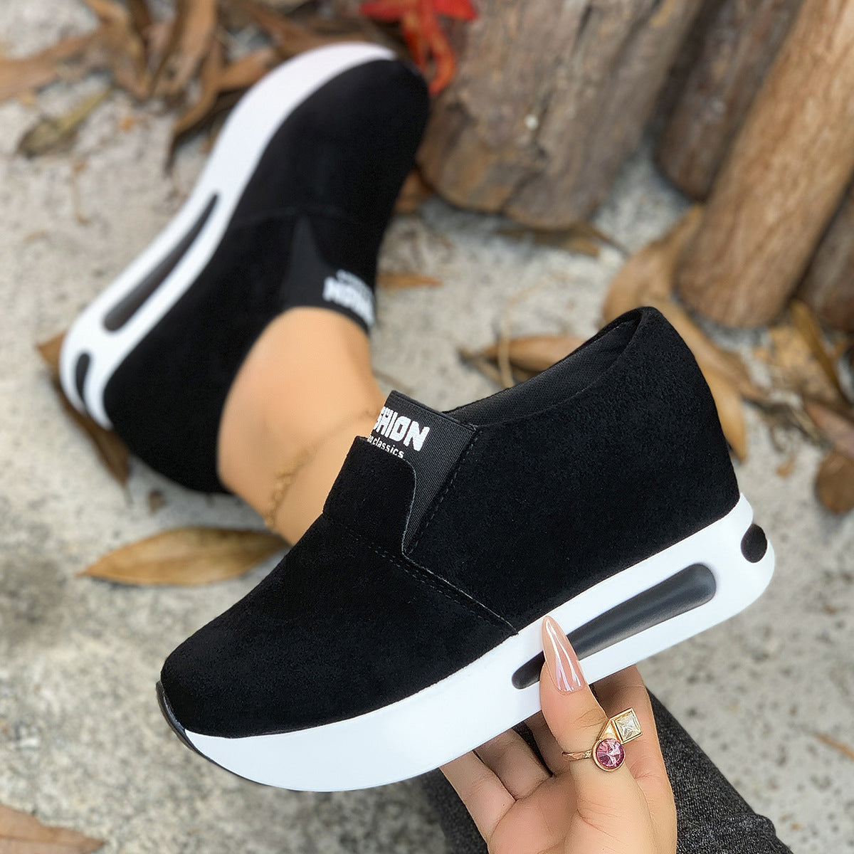 Black round toe platform slip-on sneakers with white soles and a visible air cushion detail.