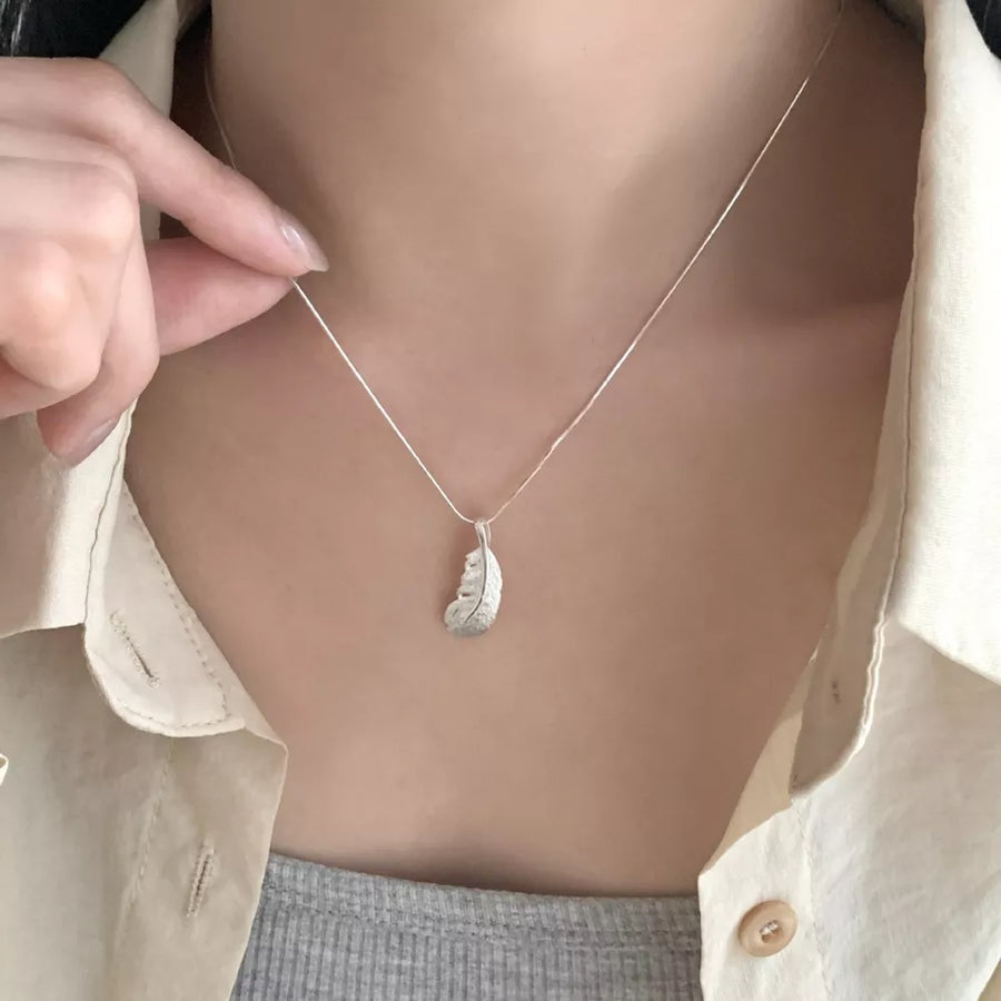 necklace in silver featuring feather pendant and straight fit