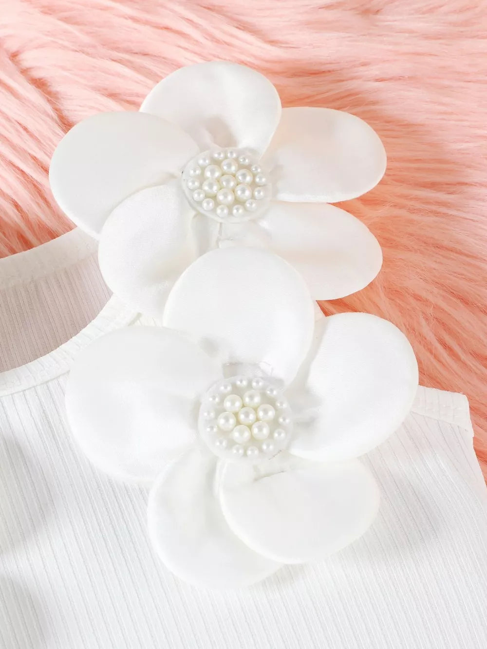 White ribbed baby top with white floral applique and pearl details.
