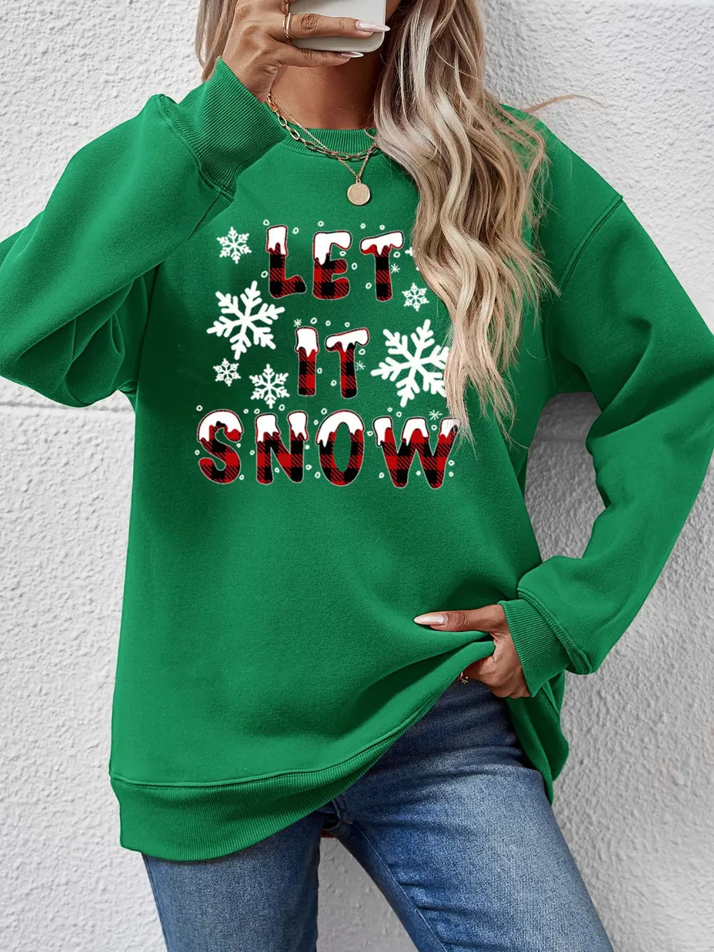Green crewneck sweatshirt with "Let It Snow" graphic and snowflakes