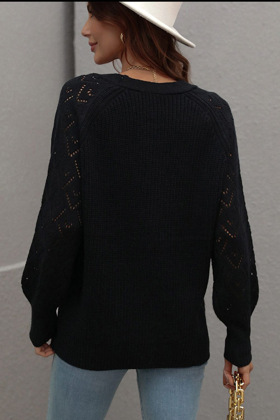 Black diamond knit cardigan with openwork sleeves and crew neck.