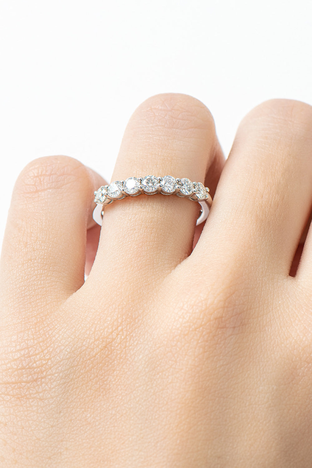 Silver band ring with seven round moissanite stones.