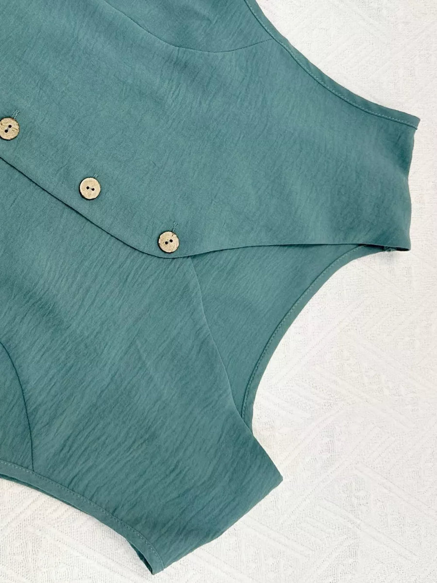 Turquoise cropped vest with button details and textured fabric.