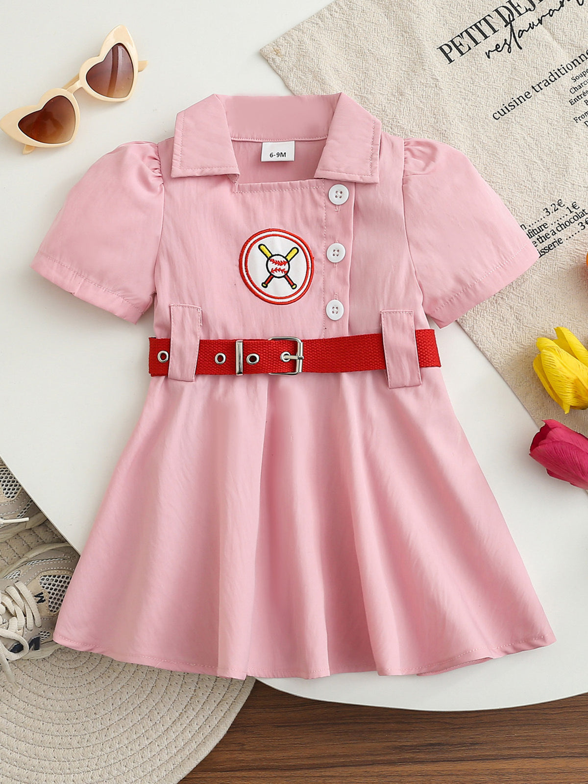 Pink cotton blend baseball dress for baby girls with embroidered logo and red belt.