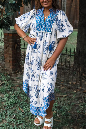 Maternity midi dress with blue floral print, tassel detail, puff sleeves, and V-neck.
