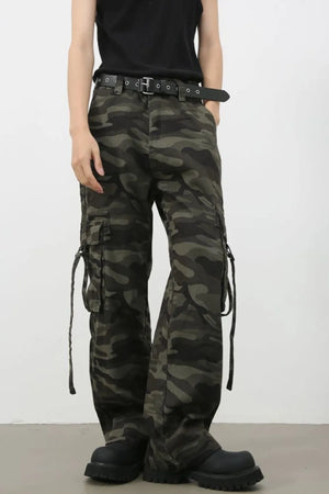Wide-leg camo cargo pants with belt detail and tie straps in green camouflage.